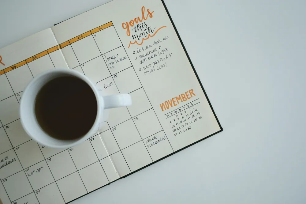 Agenda ouvert et tasse de café sur une table