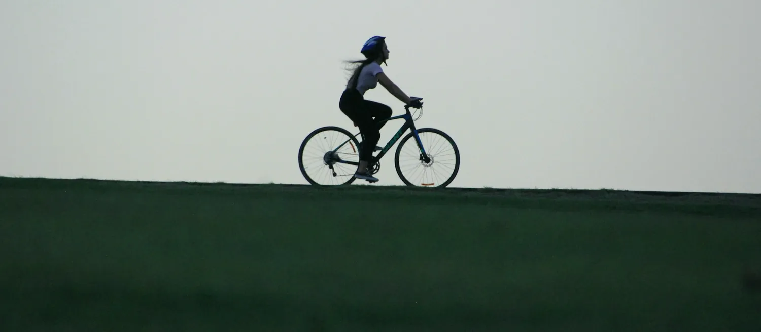 Cycliste en silhouette sur une route au lever du jour